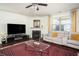 Cozy living room features a fireplace, comfortable seating, large TV, ceiling fan, and stylish decor at 3469 English Elm Way, Loganville, GA 30052