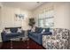 Cozy living room features comfortable sofas, patterned armchair, and a glass coffee table, creating a warm and inviting space at 3469 English Elm Way, Loganville, GA 30052