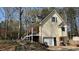 Side view of a home with a back deck, garage, mature landscaping, and lots of trees at 705 Mill Creek Rdg, Woodstock, GA 30188