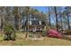 Charming two-story home featuring a front porch, inviting landscaping, and a yard filled with mature trees at 705 Mill Creek Rdg, Woodstock, GA 30188