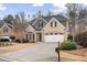 Charming two-story brick home with a well-manicured lawn, attached garage, and a mix of stone and shingle accents at 1525 Camden Cove Dr, Cumming, GA 30040