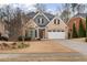 Charming two-story brick home with a well-manicured lawn, attached garage, and a mix of stone and shingle accents at 1525 Camden Cove Dr, Cumming, GA 30040