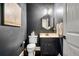 Stylish powder room with modern hexagon mirror, dark gray walls, and a charming decor at 1525 Camden Cove Dr, Cumming, GA 30040