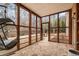 Relaxing sunroom featuring slate flooring, a hanging chair, and access to the backyard at 1525 Camden Cove Dr, Cumming, GA 30040