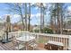 Outdoor deck with table and chairs overlooking a lush green lawn, framed by trees at 303 Valley Green Ct, Woodstock, GA 30189