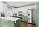 Updated kitchen with stainless steel appliances, white backsplash, and white and green cabinets at 303 Valley Green Ct, Woodstock, GA 30189