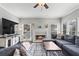 Comfortable living room features fireplace, gray sectional sofa, and many windows for natural light at 303 Valley Green Ct, Woodstock, GA 30189