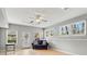 Bright living room with hardwood floors, natural light, and modern ceiling fan, plus a cozy blue sofa at 303 Valley Green Ct, Woodstock, GA 30189