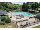 Aerial view of a community pool surrounded by chairs, umbrellas, and lush greenery at 303 Valley Green Ct, Woodstock, GA 30189