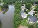 Aerial view of waterfront homes on a lake, surrounded by mature trees and manicured lawns at 335 Lake Bluff Ct, Suwanee, GA 30024