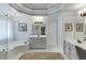 Bright bathroom features a soaking tub, neutral cabinets, chandelier, and tiled floors at 335 Lake Bluff Ct, Suwanee, GA 30024