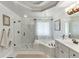 Elegant bathroom featuring separate shower and bath, chandelier, double vanity, and neutral paint at 335 Lake Bluff Ct, Suwanee, GA 30024