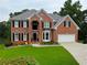 Stunning two-story brick home with a well-manicured lawn and attached two car garage at 335 Lake Bluff Ct, Suwanee, GA 30024