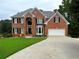 Handsome two-story brick home with lush lawn, bay window, and two-car garage at 335 Lake Bluff Ct, Suwanee, GA 30024