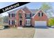 Stunning two-story brick home with lakefront views, black shutters, and a well-manicured lawn at 335 Lake Bluff Ct, Suwanee, GA 30024