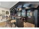 Basement bar area features custom cabinets, bar seating, beverage fridge and unique decor at 4020 Toulon Ln, Cumming, GA 30040