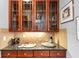 Stylish bar area with a granite countertop, ample cabinet space, and decorative tile backsplash, perfect for entertaining at 4020 Toulon Ln, Cumming, GA 30040