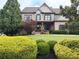 Beautifully landscaped front lawn with manicured shrubs and mature trees enhances this home's curb appeal at 4020 Toulon Ln, Cumming, GA 30040