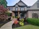 Charming two-story home features a brick facade, covered front porch with seating, and a beautifully landscaped front yard at 4020 Toulon Ln, Cumming, GA 30040