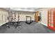 Home gym with workout equipment, a barn door, and a red door to an office at 4020 Toulon Ln, Cumming, GA 30040