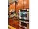 Modern kitchen with stainless steel ovens and cooktop, and wooden cabinets at 4020 Toulon Ln, Cumming, GA 30040