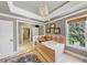 Luxurious main bathroom with a corner soaking tub, chandelier, and access to a walk-in closet at 4020 Toulon Ln, Cumming, GA 30040