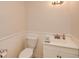 Neat powder room with white vanity, toilet and light fixture that add up to a modern look at 4400 Huntington Cir, Dunwoody, GA 30338