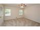 Well-lit bedroom with neutral carpet, ceiling fan, and two windows at 4400 Huntington Cir, Dunwoody, GA 30338
