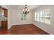 Light-filled dining room boasts a chandelier, hardwood floors, and white plantation shutters at 4400 Huntington Cir, Dunwoody, GA 30338