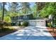 Spacious driveway leading to a two-car garage with a basketball hoop in a lush, green neighborhood at 4400 Huntington Cir, Dunwoody, GA 30338