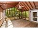 View of a large screened-in porch with wood floors, ceiling fan and an outside wooded view at 4400 Huntington Cir, Dunwoody, GA 30338