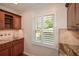 Stylish wet bar features granite counters and a window with natural light at 4400 Huntington Cir, Dunwoody, GA 30338