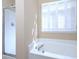 Bathroom showcasing a soaking tub, shower, and window with plantation shutters at 509 Carrington Ct, Canton, GA 30115