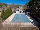 Community pool covered for the off-season, featuring a nearby pergola and surrounding evergreens at 509 Carrington Ct, Canton, GA 30115