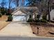 Single-story home with an attached garage, driveway, and minimal landscaping at 509 Carrington Ct, Canton, GA 30115