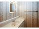 Half bathroom with wallpaper, mirror, small sink and cabinet at 165 Woodhaven Way, Alpharetta, GA 30009