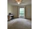 Bedroom featuring neutral walls and window overlooking a tree-filled yard at 165 Woodhaven Way, Alpharetta, GA 30009