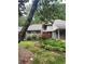 Well-maintained home exterior with mature trees, flowering shrubs, and lush lawn creating a serene setting at 165 Woodhaven Way, Alpharetta, GA 30009