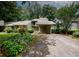 Charming home exterior with mature landscaping, a covered carport, and a welcoming entrance at 165 Woodhaven Way, Alpharetta, GA 30009