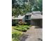 Charming home featuring a well-manicured lawn, flowering bushes, and a convenient covered carport at 165 Woodhaven Way, Alpharetta, GA 30009