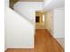 Hallway with light wood floors leads to a living room and a cozy fireplace, creating a warm welcome at 165 Woodhaven Way, Alpharetta, GA 30009