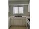 Functional kitchen with white cabinets, stainless steel sink, and a view of the outdoors through the window at 165 Woodhaven Way, Alpharetta, GA 30009