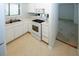 Compact kitchen with white cabinets, modern appliances, a double sink, and easy access to the living area at 165 Woodhaven Way, Alpharetta, GA 30009