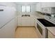 Bright kitchen with white appliances, countertops, and cabinets, offering ample storage and functionality at 165 Woodhaven Way, Alpharetta, GA 30009