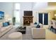 Well-appointed living room with fireplace, neutral furniture, and large windows for ample natural light at 165 Woodhaven Way, Alpharetta, GA 30009