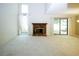Cozy living room with fireplace and tall ceilings, with sliding doors offering seamless outdoor access at 165 Woodhaven Way, Alpharetta, GA 30009
