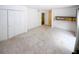 Bright, carpeted living room with closet and serving hatch to the kitchen at 165 Woodhaven Way, Alpharetta, GA 30009