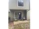 A small patio with seating with sliding glass doors leading into the home at 165 Woodhaven Way, Alpharetta, GA 30009
