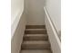 A carpeted staircase with a white banister at 165 Woodhaven Way, Alpharetta, GA 30009