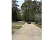 Long driveway leading to a home surrounded by lush greenery and mature trees at 3200 Farmington, Vinings, GA 30339